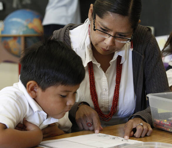 Teacher aide Ava Lee works with a student in the first-grade class at St. Francis of Assisi School in Gallup, N.M. (CNS photo/Bob Roller)