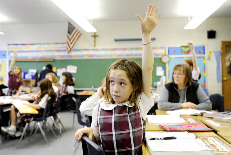 Fourth-grader Shannon Lawless raises her hand to answer a question Dec. 20, 2011, at Christ the King School in Irondequoit, N.Y. (CNS photo/Mike Crupi, Catholic Courier) 