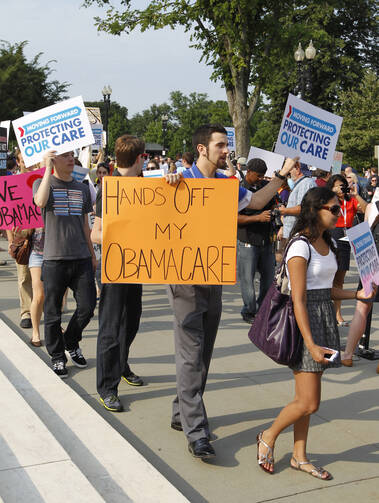 Supporters of the Obama administration's health care reform law demonstrate in front of the U.S. Supreme Court. (CNS photo/Bob Roller) 