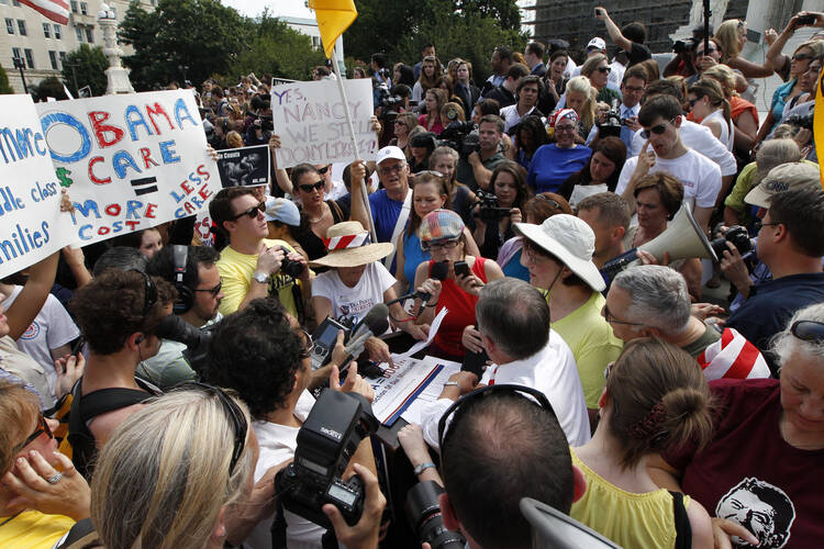 Protesters react to a 2012 Supreme Court ruling that upheld the Affordable Care Act. The court has another chance to largely dismantle the law this spring. (CNS photo/Bob Roller)