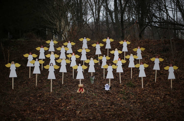 Twenty-seven wooden painted angels created by Eric Mueller are displayed outside his home in Newtown, Conn. (CNS photos/Mike Segar, Reuters). 