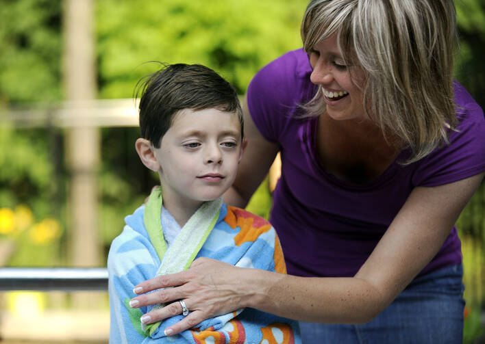 A mother helps her son dry off after a dip in the pool in the summer of 2012 in Fairport, N.Y. (CNS photo/Mike Crupi, Catholic Courier)