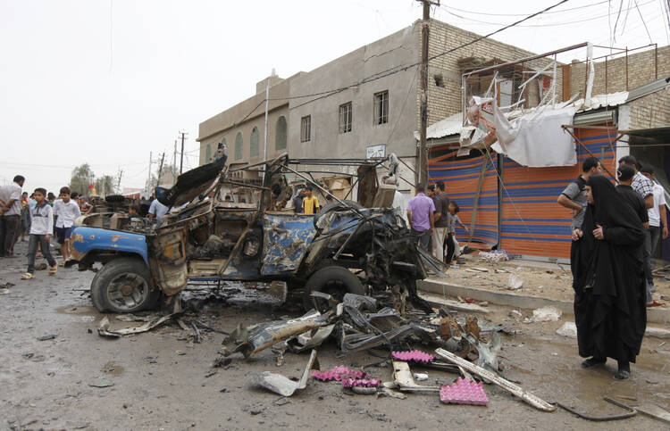 Residents gather at site of deadly car bomb attack in Baghdad, May 20 (CNS pho to/Mohammed Ameen, Reuters)