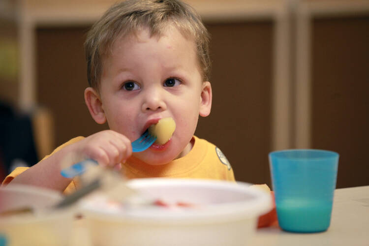 Charlie Escobar, 3, bites into breakfast at the Baltimore Catholic Charities Head Start program in Edgewood, Md., June 13 (CNS photo/Nancy Phelan Wiechec) 