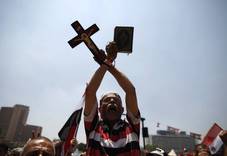 A protester in Egypt holds up copy of Quran and a cross during a rally at Cairo's Tahrir Square (CNS photo/Khaled Abdullah, Reuters)