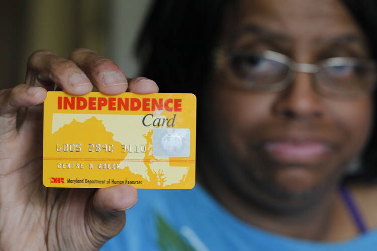 Denise Green displays her "Independence Card," which is issued by the state of Maryland and holds federal SNAP benefits, at her home in Silver Spring, Md., June 19. (CNS photo /Bob Roller) 