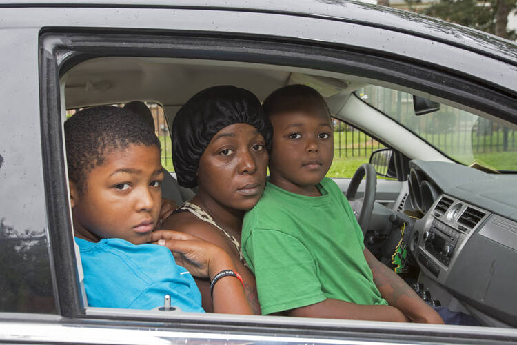 Homeless family living out of car pose for photo in Detroit. (CNS photo/Jim West) 