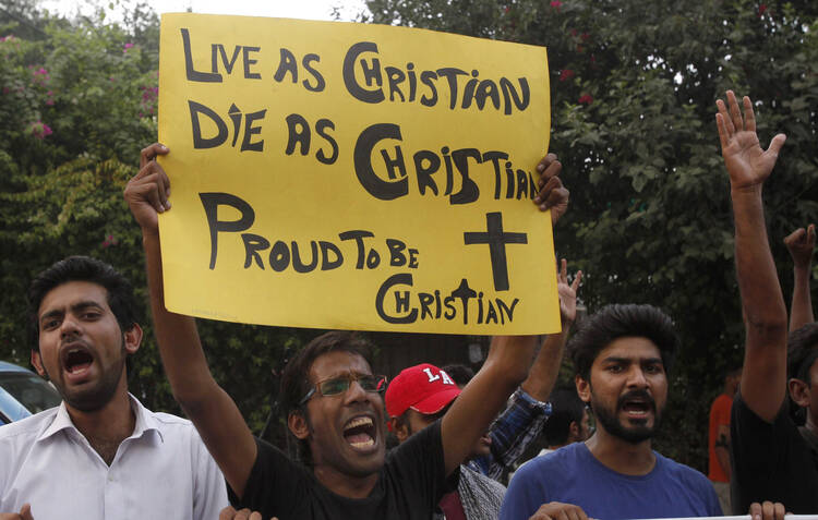 Member of Christian community holds placard during rally to condemn suicide attack on church in Pakistan.