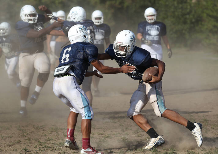 Player attempts to make tackle during football practice at Maryland Catholic high school. (CNS photo /Bob Roller)