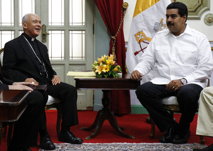 Venezuela's President Maduro talks with Archbishop Padron during meeting in Caracas.