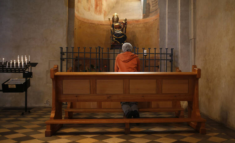 Woman kneels in prayer inside Limburg Cathedral (CNS photo/Kai Pfaffenbach, Reuters) 