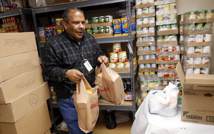 Volunteer carries bags of food for Emergency Assistance Department at Chicago Catholic Charities (CNS photo/Jim Young, Reuters)