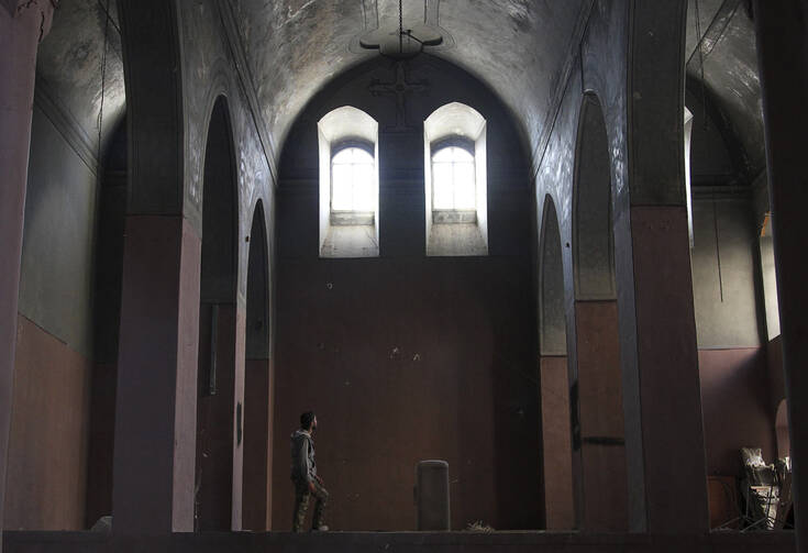 A Free Syrian Army fighter walks inside a church in Aleppo, Syria, Nov. 4. (CNS photo/Molhem Barakat, Reuters)