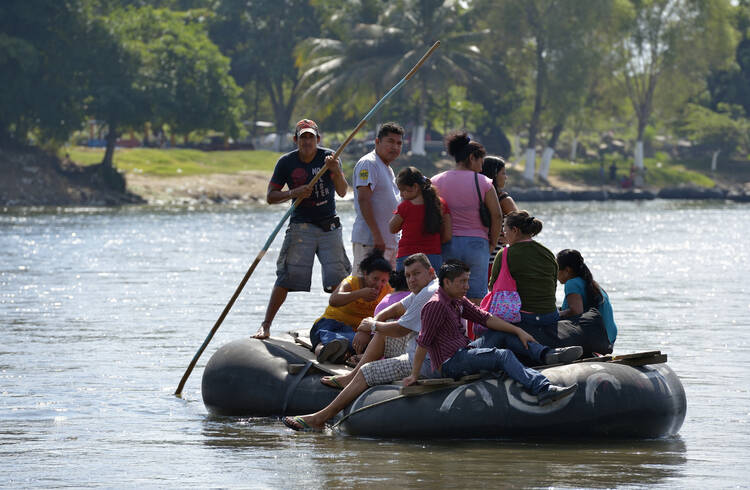 Migrants and others cross the Suchiate River where it forms a border between Guatemala and Mexico Dec. 18. The river crossing is part of the main route that Central American migrants follow on their way north. (CNS photo/Paul Jeffrey) 