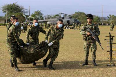 Colombian soldiers carry the bodies of Revolutionary Armed Forces of Colombia rebels killed in combat at an army base in Tame in 2014. (CNS photo/Jose Miguel Gomez, Reuters)