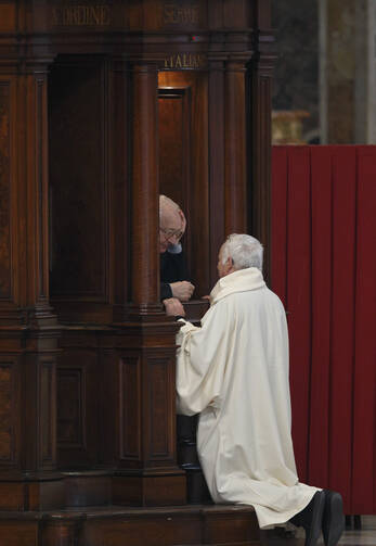 Priest hears confession of clergy member in St. Peter's Basilica at Vatican. (CNS photo/Paul Haring)