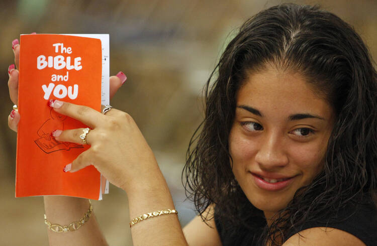  A young woman holds a Bible study guide while attending a New Testament class at St. Luke Church in Brentwood, N.Y. (CNS photo/Gregory A. Shemitz)