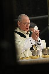 Cardinal Dolan of New York elevates Eucharist during Mass celebrated for St. Patrick's Day at St. Patrick's cathedral in New York (CNS photo/Gregory A. Shemitz).