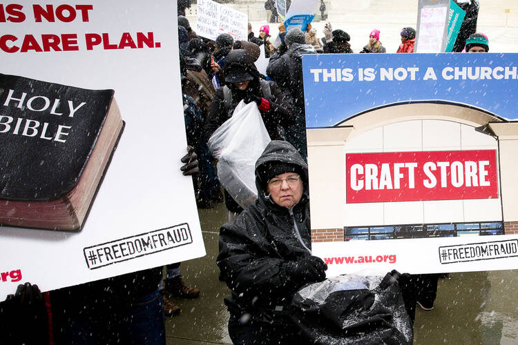 Supporter of federal contraceptive mandate holds sign in front of U.S. Supreme Court in Washington. (CNS photo/Tyler Orsburn)