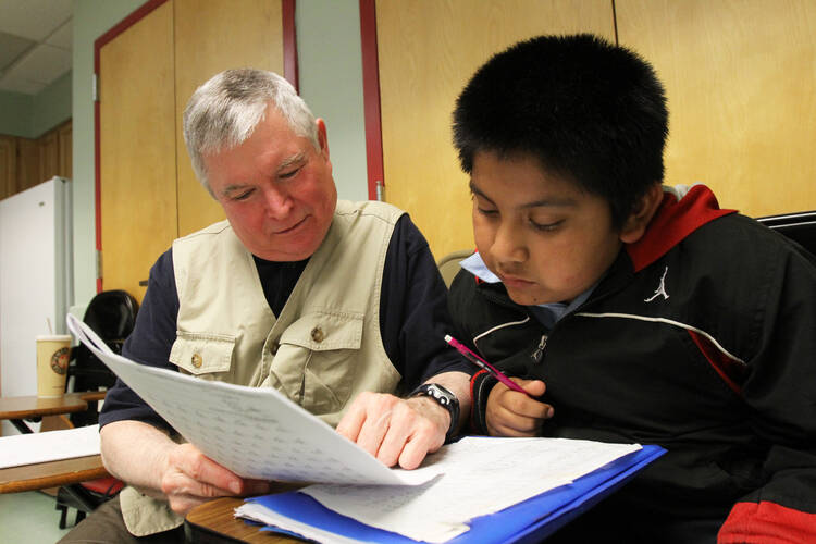 Member of Ignatian Volunteer Corps tutors boy during after-school program at Mercy Center in New York.