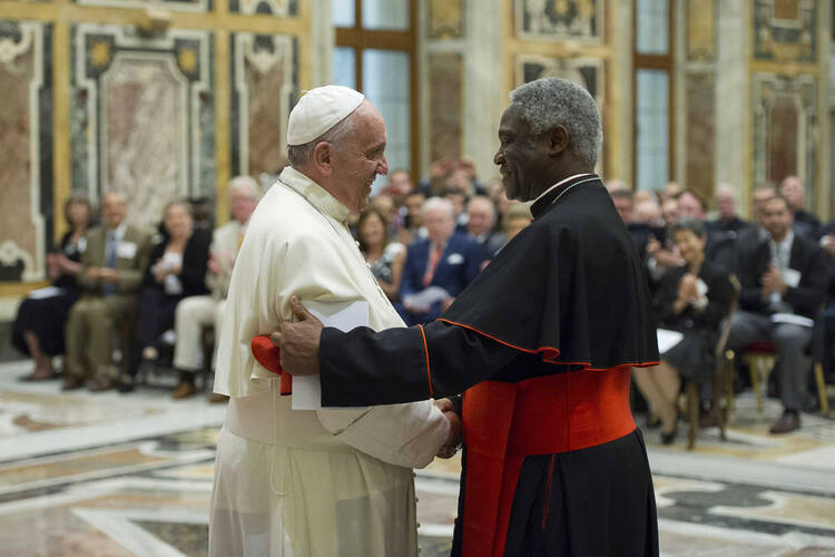  Pope Francis shakes hands with Ghanaian Cardinal Peter Turkson, president of the Pontifical Council for Justice and Peace, during a meeting with council members at the Vatican June 16. (CNS photo/L'Osservatore Romano via Reuters)