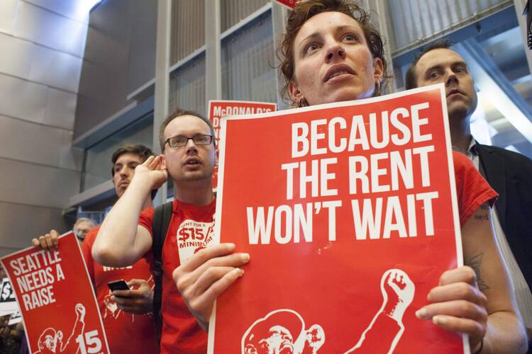 Activists rally for a minimum-wage increase last year in Seattle, one of several major cities that have grown impatient with a lack of action in Washington, D.C. (CNS photo/David Ryder, Reuters)