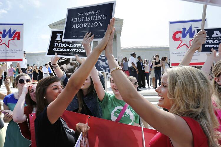 Pro-life demonstrators celebrate June 30 outside the U.S. Supreme Court in Washington as its decision in the Hobby Lobby case is announced. (CNS photo/ Jonathan Ernst, Reuters)