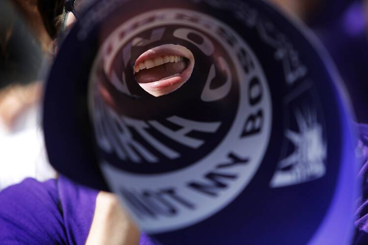 Demonstrator chants in support of federal contraception mandate outside U.S. Supreme Court. (CNS photo/Jonathan Ernst, Reuters) 