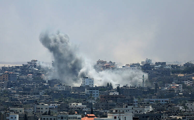 Smoke rises from Gaza City after an Israeli airstrike July 29. Violence escalated the previous night after an attempted unofficial truce for the three-day Eid al-Fitr holiday crumbled. (CNS photo/Mohammed Saber, EPA)