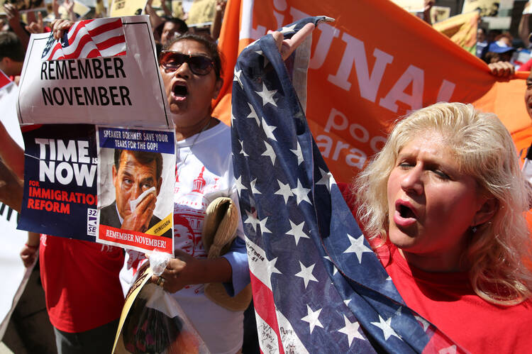 Protesters hold banners and flags during an immigration rally and march outside the U.S. Immigration and Customs Enforcement headquarters in Washington Aug. 28. (CNS photo/Bob Roller)
