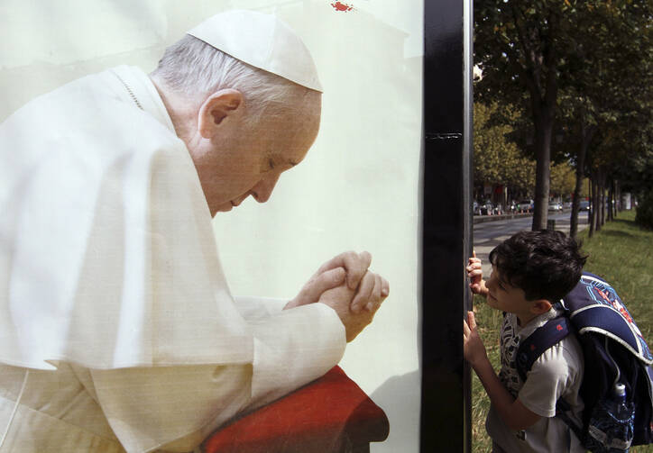 A boy looks at a poster of Pope Francis in Tirana, Albania, Sept.19. The pope will be making a day trip to Albania Sept. 21. (CNS photo/Arben Celi, Reuters)