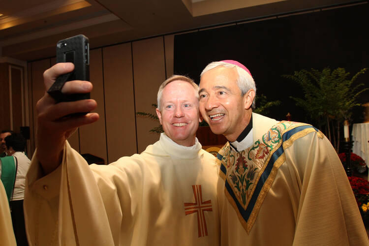 Vatican official, Denver archdiocesan vocations director pose for selfie during vocation conference. (CNS photo/Gregory A. Shemitz)