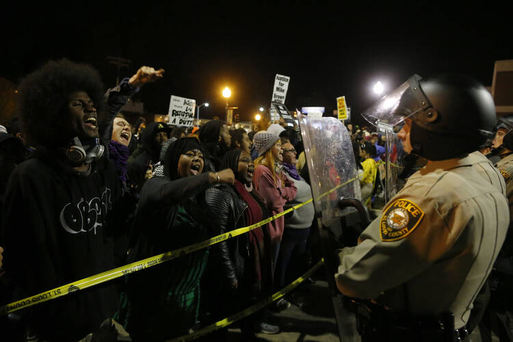 Protesters square off against police during a rally for Michael Brown outside the police department in Ferguson. (CNS photo/Jim Young, Reuters)