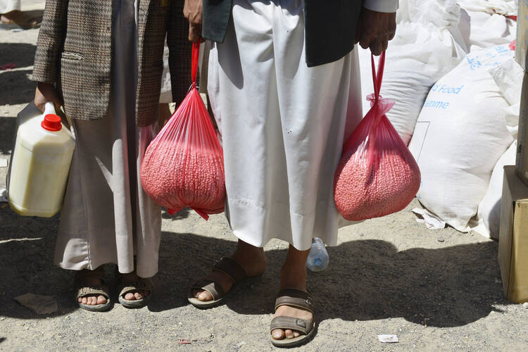 Yemenis receive food at a distribution center in Sana'a, Yemen earlier this year.