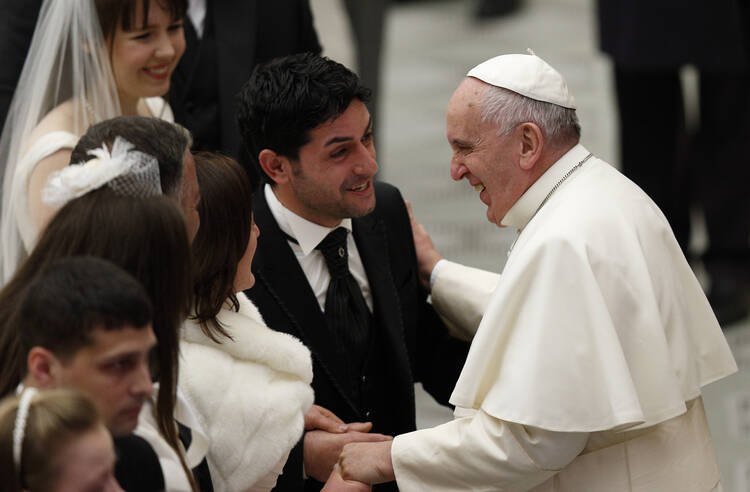 Pope Francis shares a laugh with a newly married couple during his general audience in Paul VI hall at the Vatican Jan. 7. (CNS photo/Paul Haring)