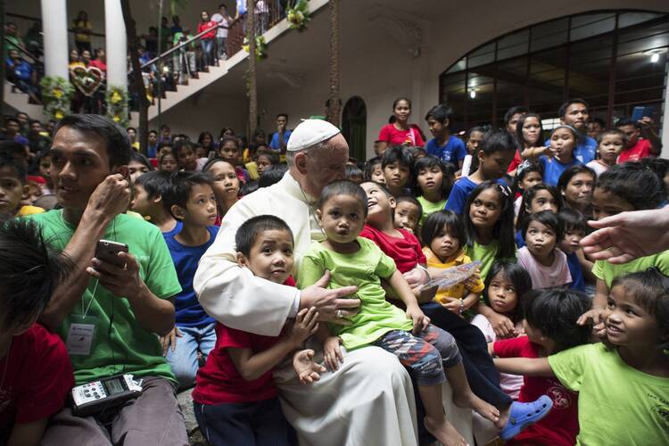 Pope Francis pictured with youths at home for former street children in Manila.