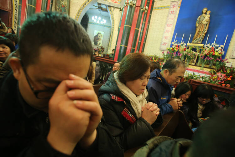 Chinese Catholics pray during a 2014 Mass in Beijing. Pope Francis asked Catholics worldwide to show solidarity through their prayers for Catholics in China and for persecuted Christians over the Pentecost weekend. (CNS photo/Wu Hong, EPA) 