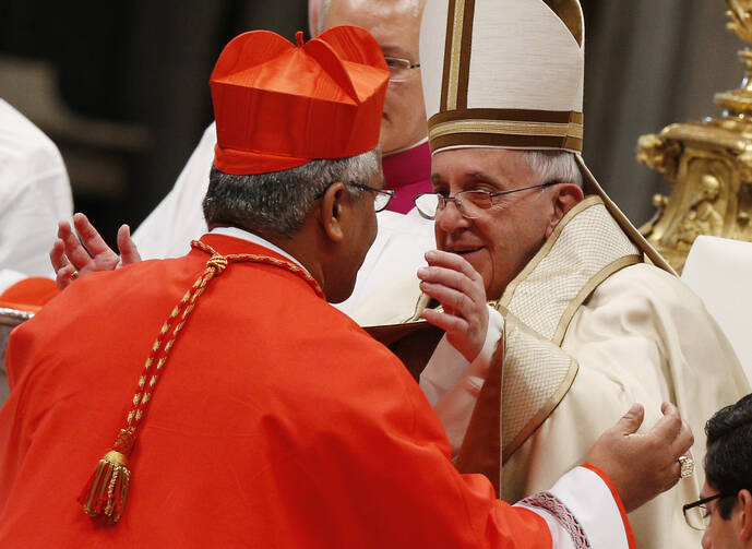 Pope Francis greets new Cardinal Soane Mafi of Tonga during the February 2015 consistory at St. Peter's Basilica at the Vatican. (CNS photo/Paul Haring)