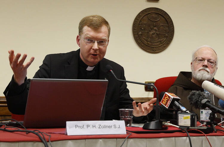 Jesuit Father Hans Zollner, president of the Center for Child Protection at the Pontifical Gregorian University in Rome, speaks at a news conference officially launching the center in February 2015. Also pictured is Cardinal Sean P. O'Malley of Boston, head of the Pontifical Commission for Child Protection. (CNS photo/Paul Haring)