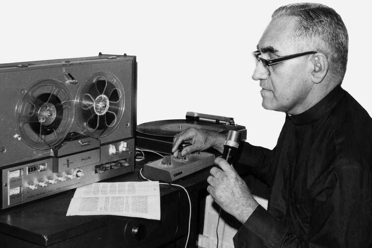 Archbishop Oscar Romero of San Salvador is seen in undated photo working in improvised radio studio.