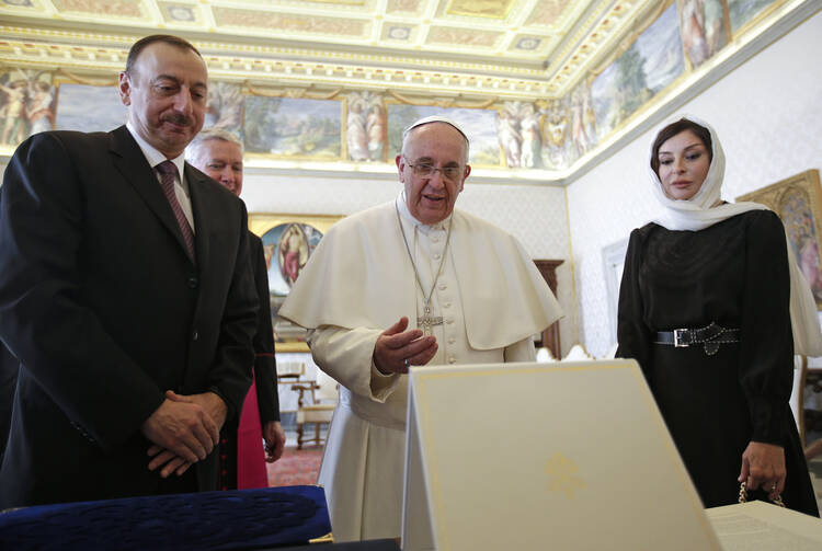 Pope Francis receives a gift from Azerbaijani President Ilham Aliyev and his wife, Mehriban Aliyeva, during a meeting at the Vatican in March 2015. (CNS photo/Max Rossi, Reuters)