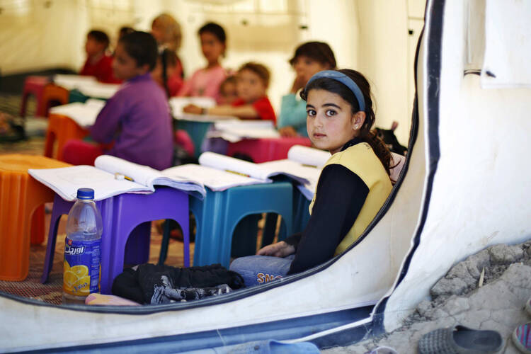 A Syrian girl looks out from a UNICEF tent in an informal settlement near Amman, Jordan, March 14. 