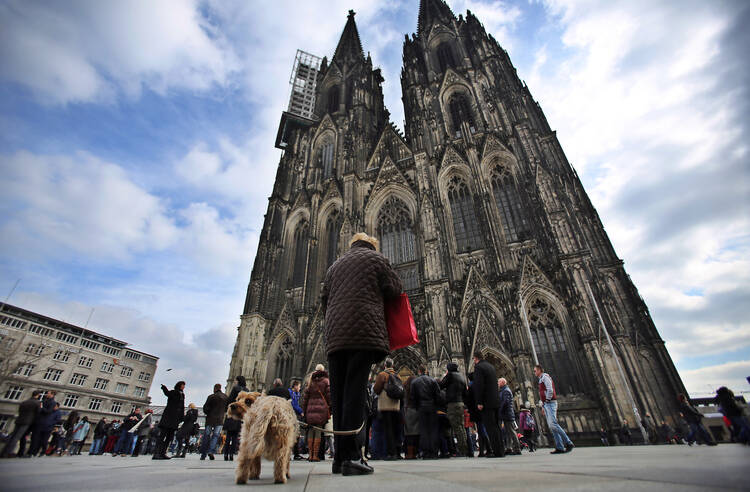 People stand during a moment of silence for the victims of the Germanwings flight crash in front of the Cologne Cathedral in Cologne, Germany, March 26. (CNS photo/Oliver Berg, EPA)