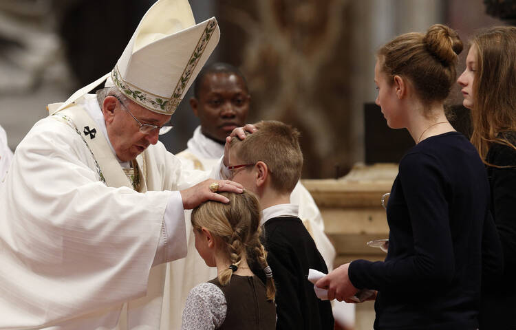Pope Francis greets children in offertory procession at Holy Thursday chrism Mass in St. Peter's Basilica at Vatican.