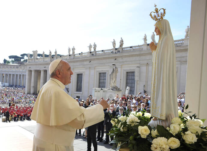 Pope Francis prays in front of a statue of Our Lady of Fatima during his general audience in St. Peter's Square at the Vatican May 13. The statue, which was present for the May 13 feast of Our Lady of Fatima, is a copy of the original in Fatima, Portugal. (CNS photo/L'Osservatore Romano, pool) 