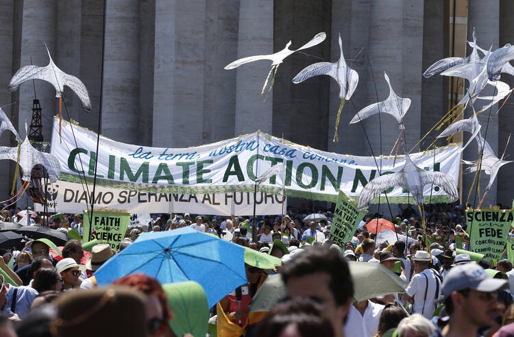 A banner calling attention to climate change is seen in St. Peter's Square at the Vatican June 28. Some 1,500 people marched to the Vatican in support of Pope Francis' recent encyclical on the environment. (CNS photo/Paul Haring) 