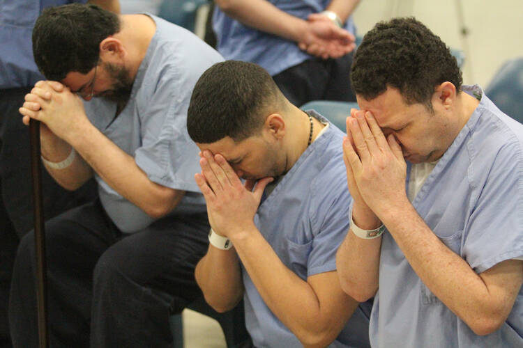 Prison inmates at Curran-Fromhold Correctional Facility in Philadelphia pray during a Mass in mid-January. Pope Francis has a planned visit to the prison Sept. 27 during his two-day visit to the city. (CNS photo/Sarah Webb, CatholicPhilly.com)