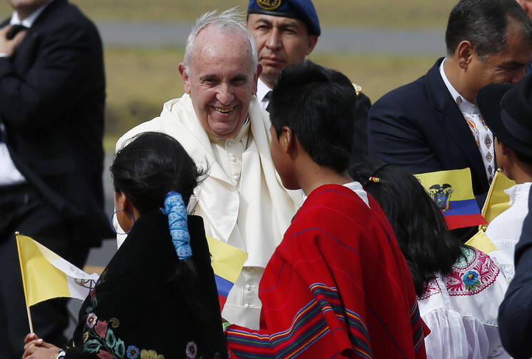 Pope Francis greets children in traditional dress as he arrives at Mariscal Sucre International Airport in Quito, Ecuador, July 5. The pope is making an eight-day trip to Ecuador, Bolivia and Paraguay. (CNS photo/Paul Haring)