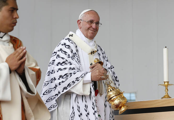 Pope Francis smiles at someone while using incense during Mass in Bicentennial Park in Quito, Ecuador, July 7. (CNS photo/Paul Haring) 