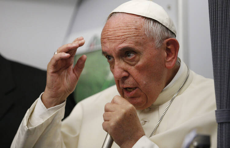 Pope Francis answers questions from journalists aboard his flight from Asuncion, Paraguay, to Rome July 12. (CNS photo/Paul Haring) 